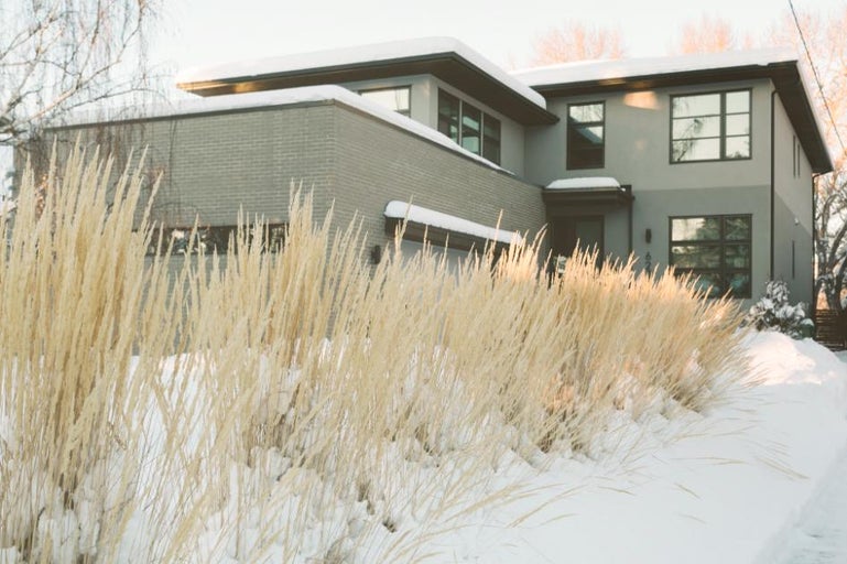 O casă modernă cu iarbă ornamentală în timpul iernii