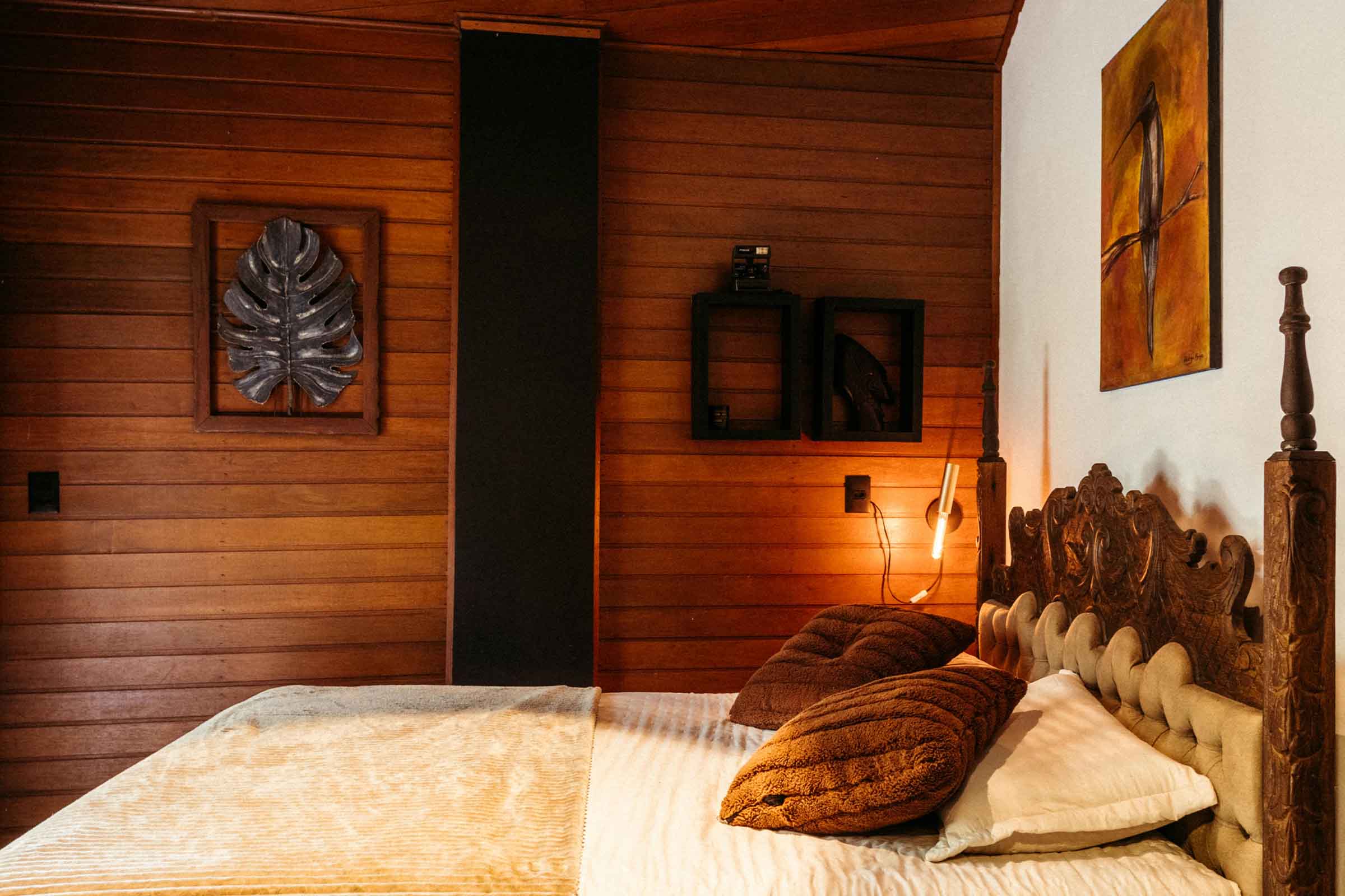 Dormitor cu lambriuri din lemn, pat și elemente decorative