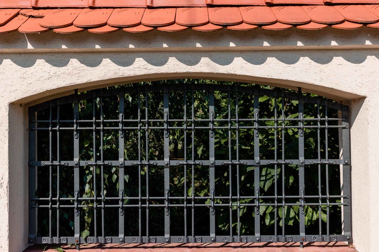 Fereastră cu gratii într-o clădire cu acoperiș din țiglă