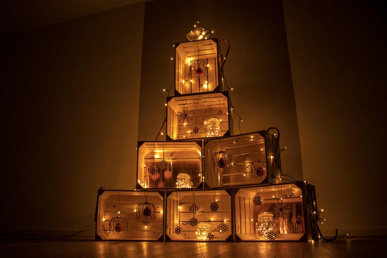 Piramidă decorativă din lăzi de lemn cu iluminare și elemente decorative