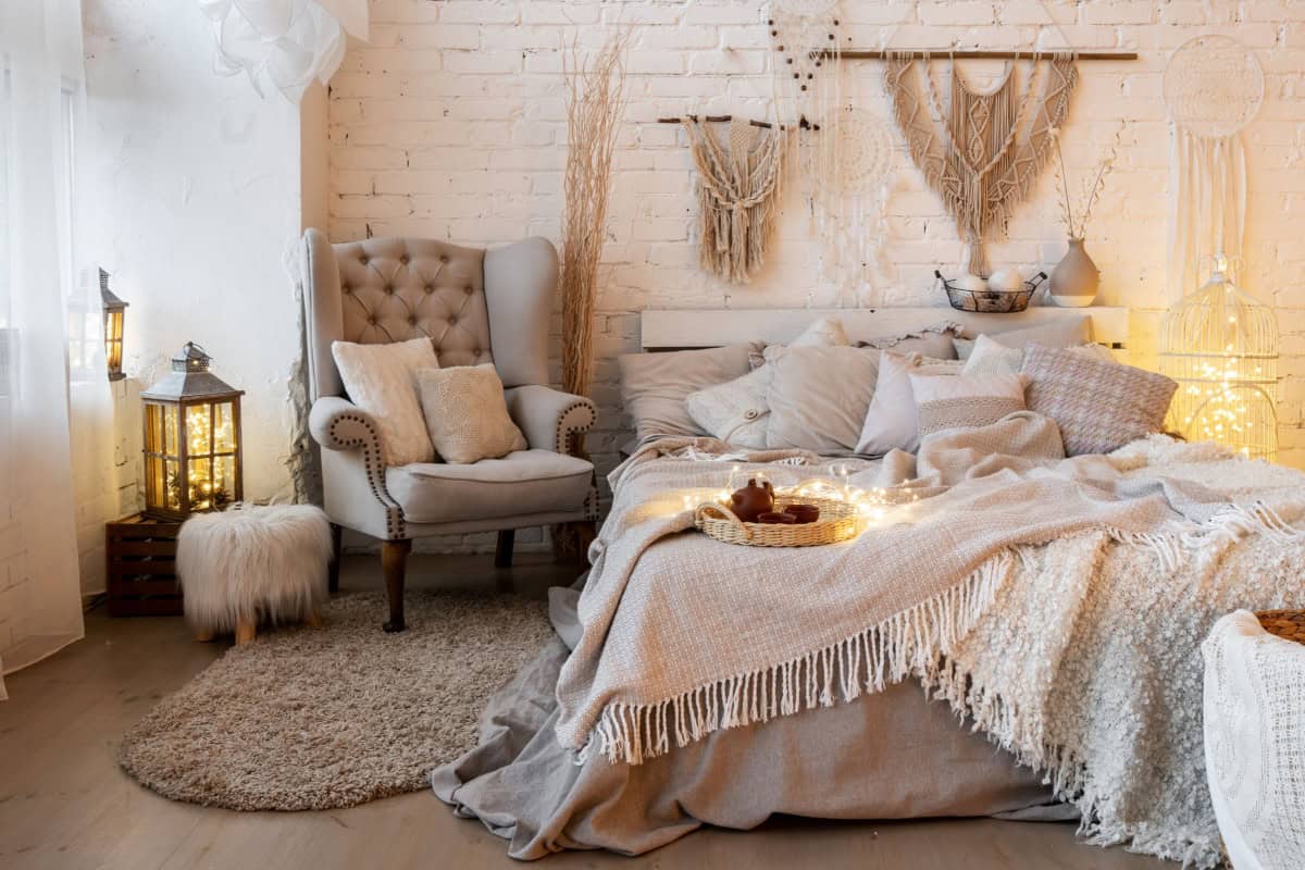 Dormitor confortabil cu fotoliu, pat și elemente decorative în stil boem