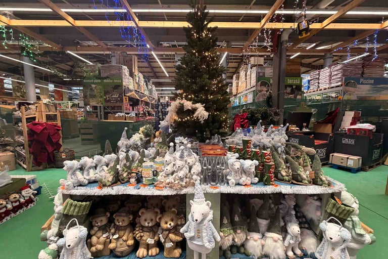 Târg de Crăciun în magazinul Hornbach cu pom împodobit, numeroase jucării din pluș precum urși polari și spiriduși și decorațiuni festive.