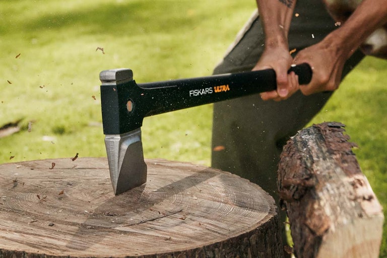 Topor Fiskars Ultra folosit pe un trunchi de lemn.