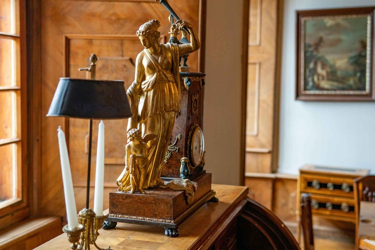 Scenă decorativă cu ceas, statuie și sfeșnic