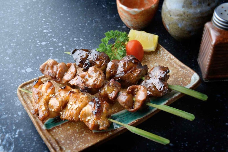 Trei frigarui de pui cu o felie de lămâie pe o farfurie