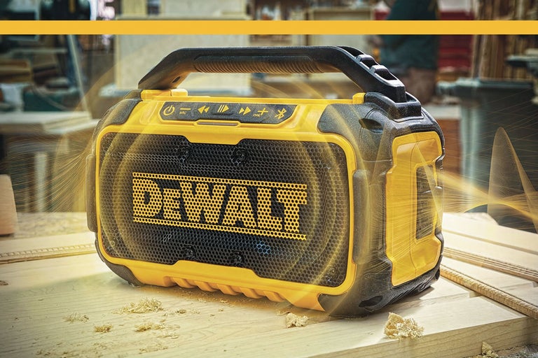 Radio de șantier cu acumulator DeWalt cu Bluetooth și mâner de transport pe un banc de lucru.