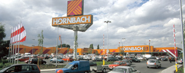 Vedere exterioară a unei filiale Hornbach cu parcare.