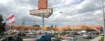 Vedere exterioară a unei filiale Hornbach cu parcare.