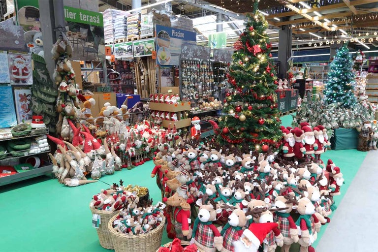 Decorațiuni de Crăciun în magazinul Hornbach cu brazi de Crăciun, Moși Crăciuni și reni.