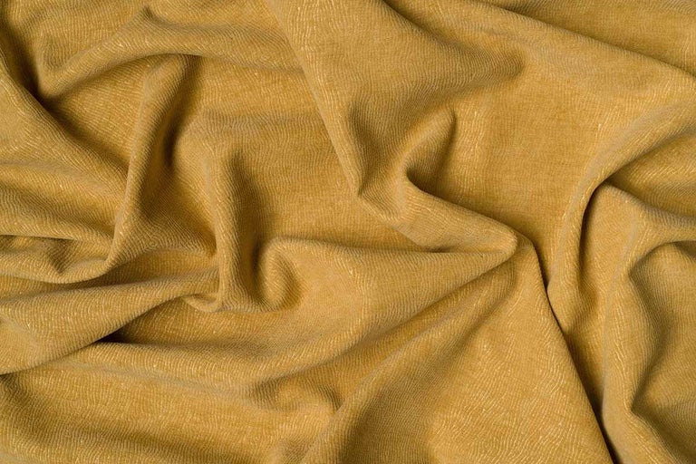 Imagine detaliată a unei țesături decorative galbene, cu pliuri
