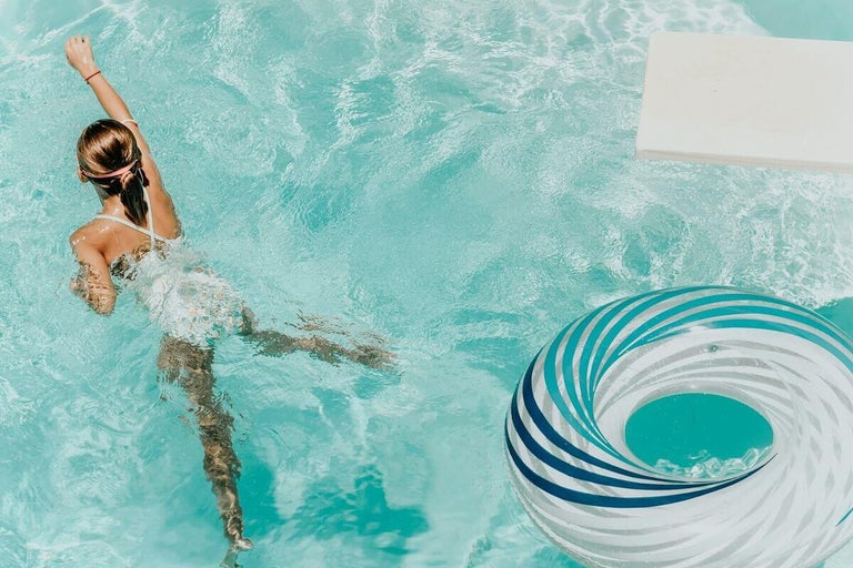 Vedere de sus a unei piscine cu înotător, trambulină și colac de înot