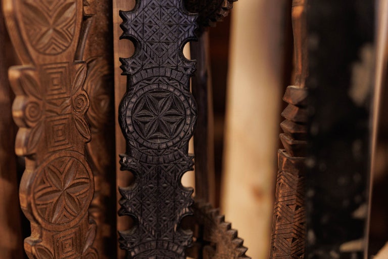 Prim-plan cu sculpturi decorative în lemn, cu modele geometrice.