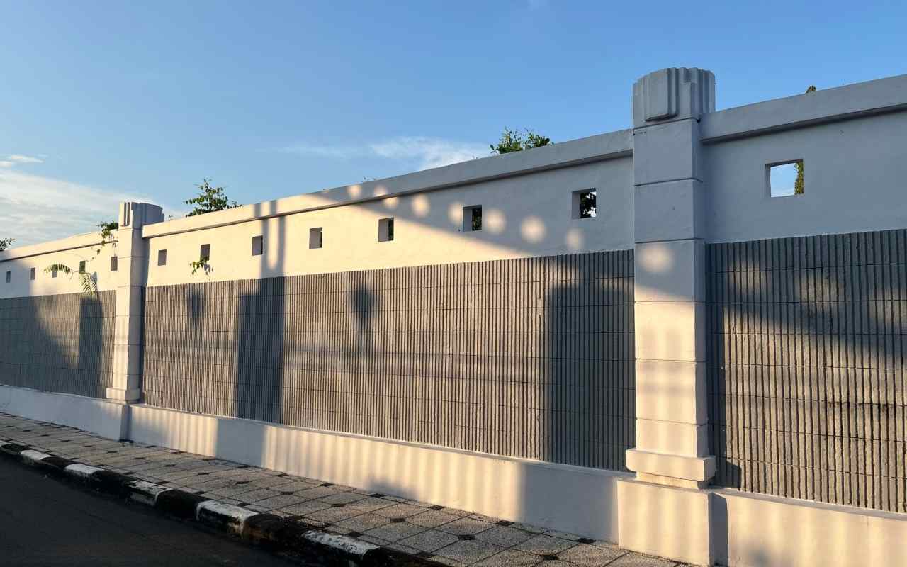 Un gard din beton cu stâlpi și deschideri
