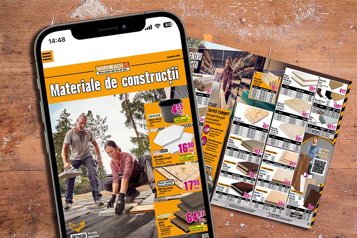Smartphone și cataloage cu materiale de construcții pe o masă din lemn