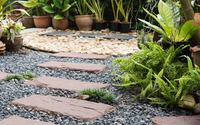 Cărare de grădină cu plăci de piatră, pietriș și plante