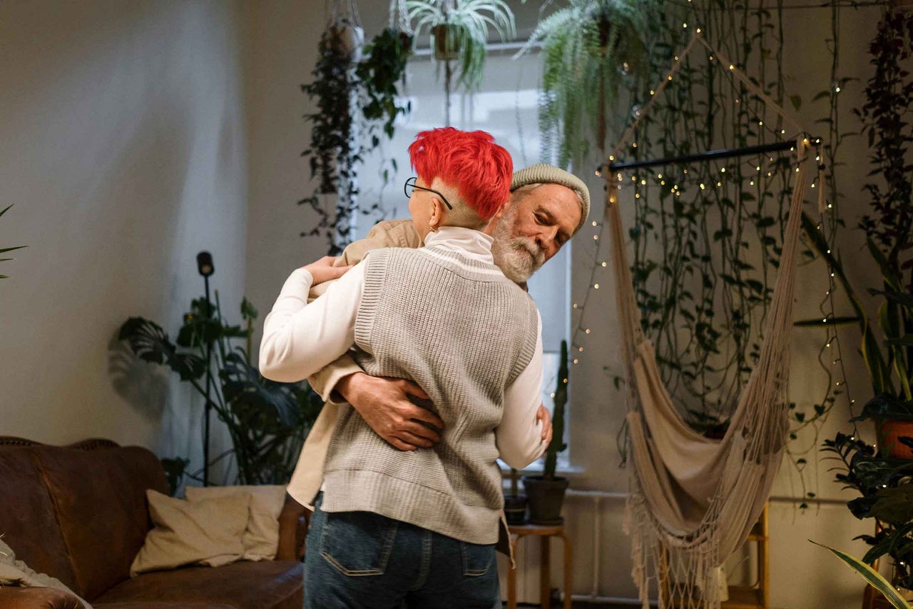 Îmbrățișare într-o cameră cu plante suspendate și un hamac