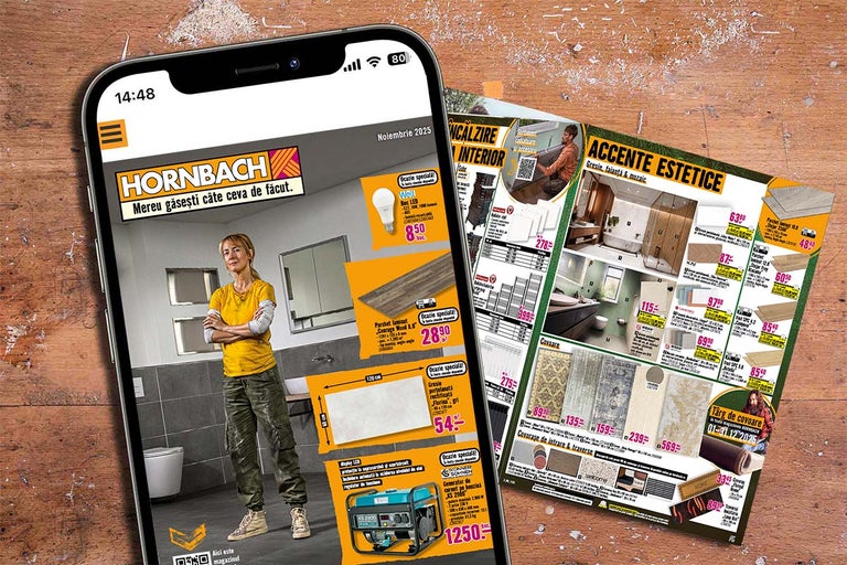 Telefonul arată reclama Hornbach lângă broșura Hornbach pe o masă de lemn