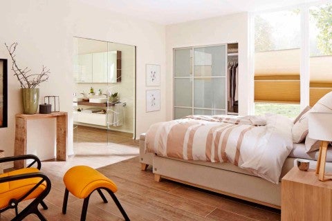 Dormitor luminos cu pat, scaune și acces la baie