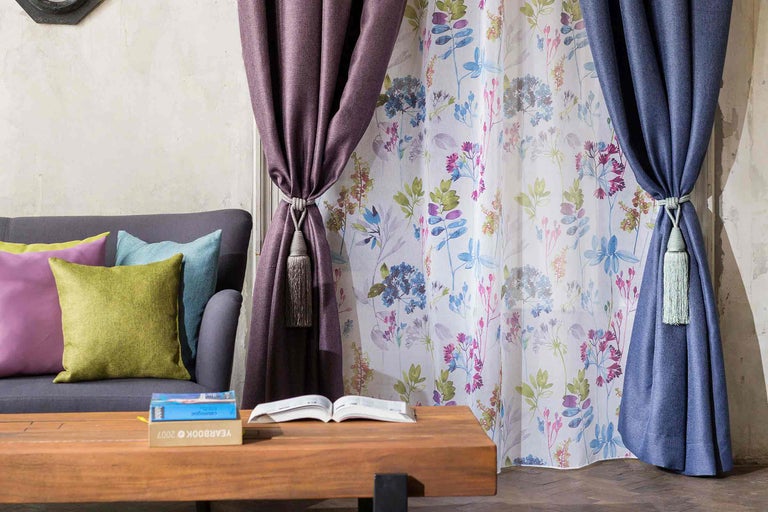 Scenă de living cu perdele, canapea și măsuță de cafea