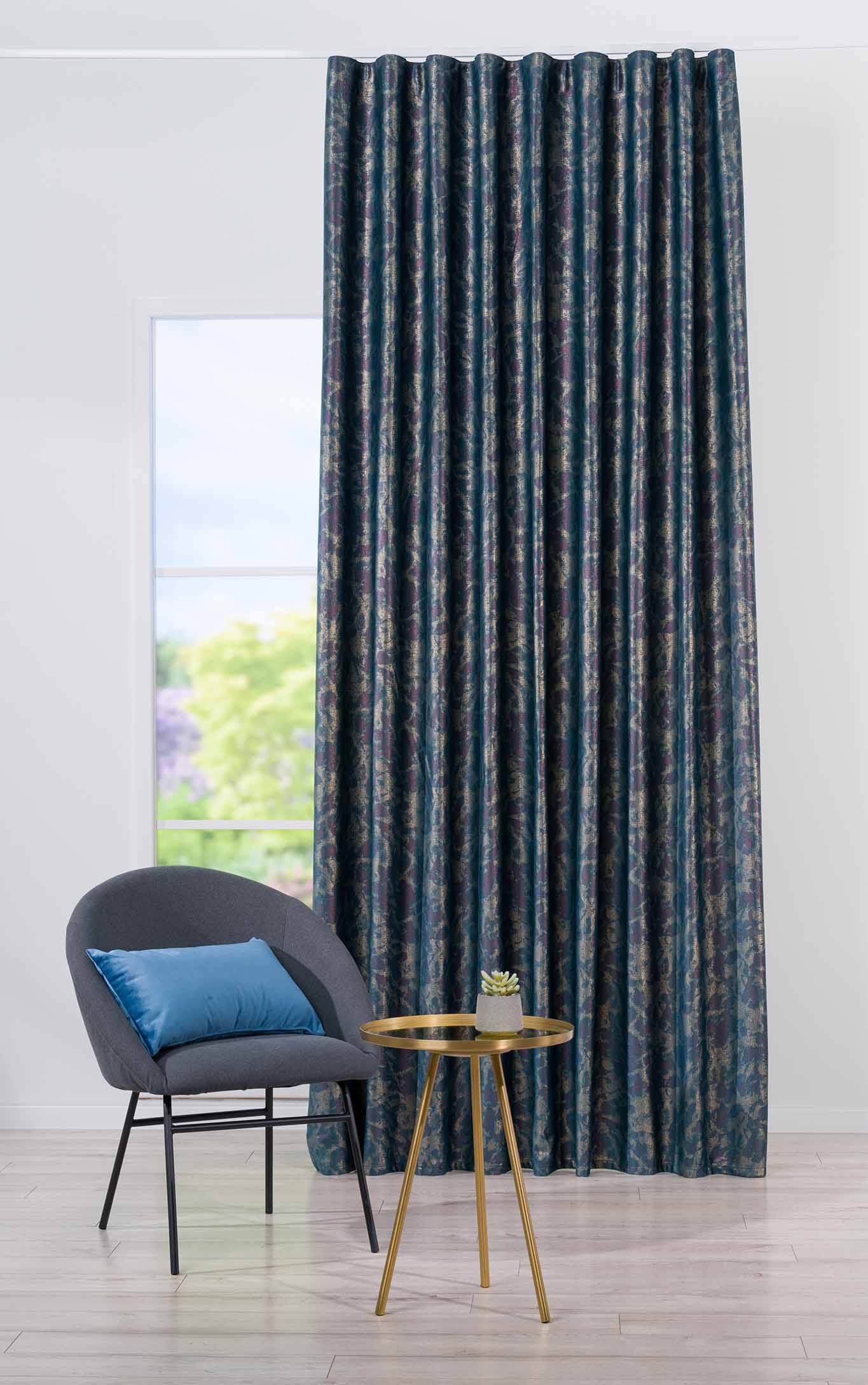 Cortină decorativă lângă un fotoliu și o măsuță laterală