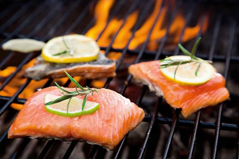 Fileuri de somon cu felii de lămâie și rozmarin pe un grătar