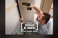 Un meșter montează un panou acustic din lamele de lemn pe un perete cu o mașină de înșurubat, Hornbach Servicii de Montaj.