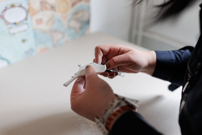 Mâini care prelucrează un decor din gips.