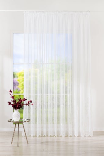 Șaluri decorative cu model floral în fața unei ferestre