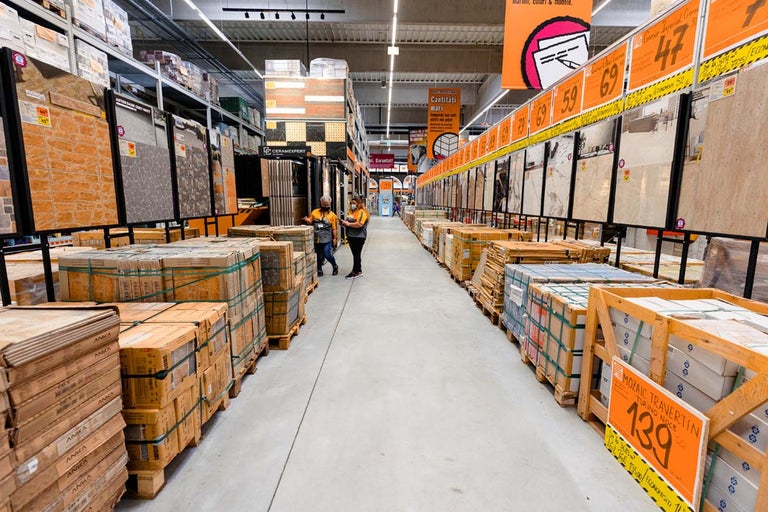 Vedere culoar în magazinul de bricolaj Hornbach cu plăci ambalate și exponate de plăci