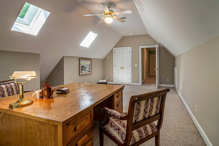 Birou cu birou din lemn, scaun, lampă și ferestre de mansardă