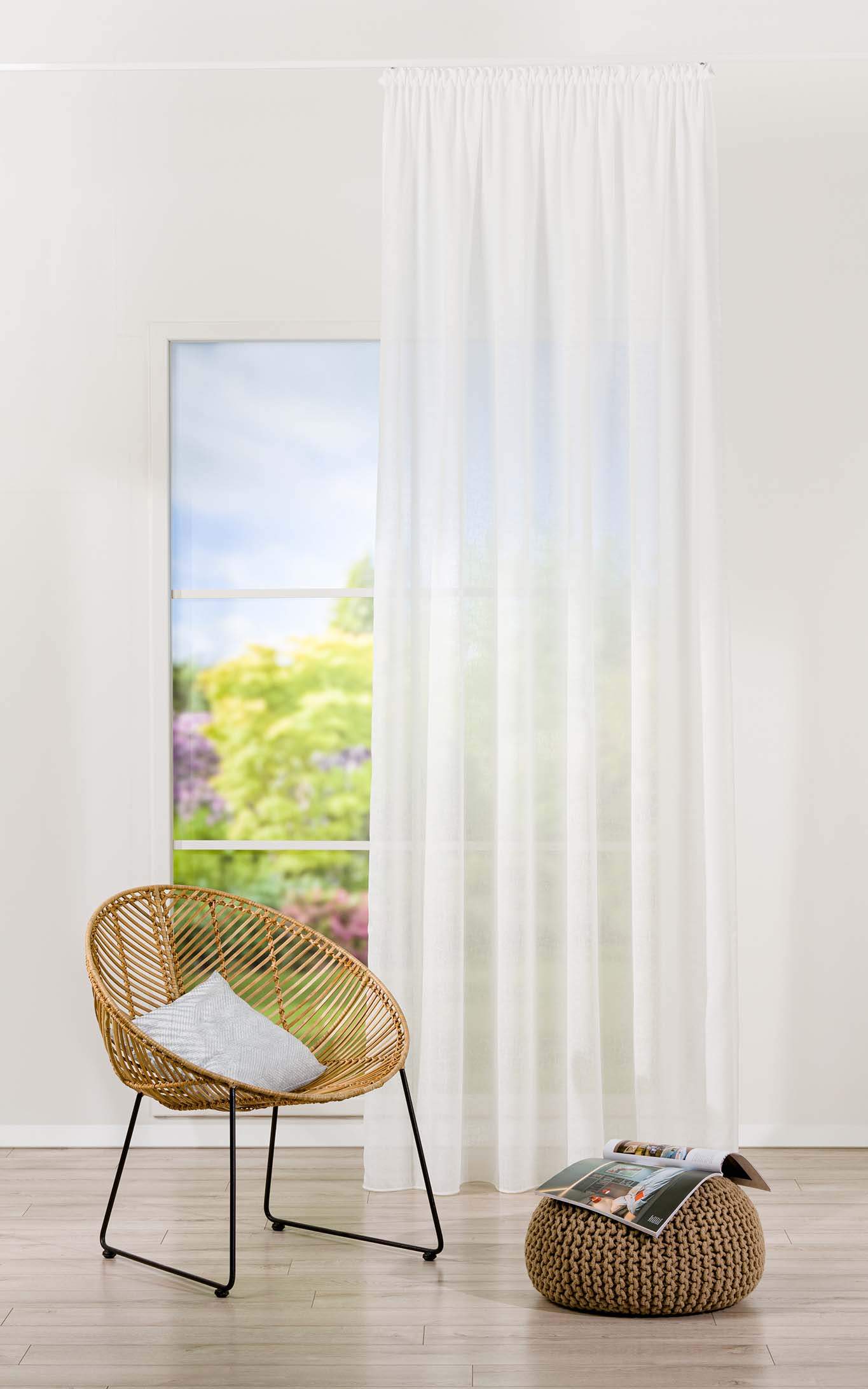 Atmosferă decorativă de locuit cu fereastră, perdea, fotoliu și puf