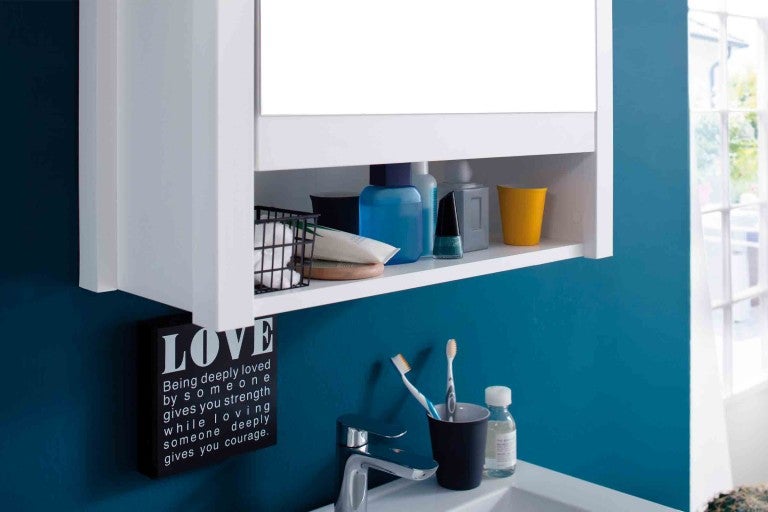 Baie cu dulap cu oglindă și diverse articole de baie pe un raft.