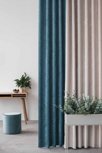 Spațiu decorativ cu perdele, birou, taburet și plante pentru o atmosferă confortabilă.