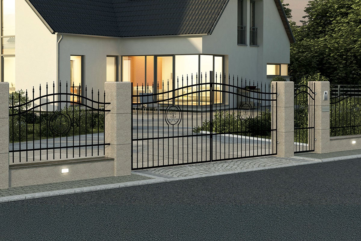O poartă metalică elegantă cu două canate, cu elemente din fier forjat și vârfuri decorative, instalată în fața unei case cu stâlpi de piatră.