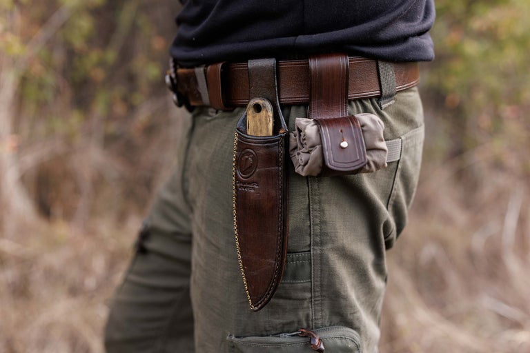 Persoană cu curea, teacă de cuțit și buzunar mic