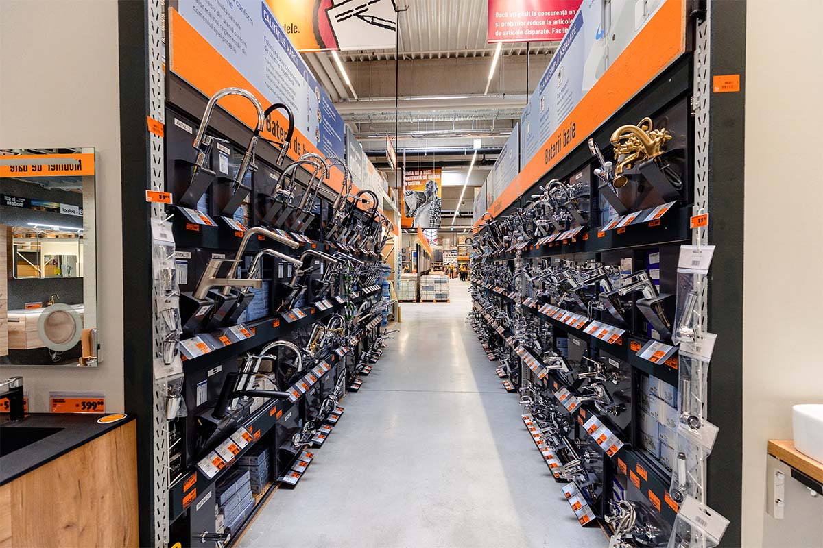 Vedere culoar în magazinul de bricolaj Hornbach cu rafturi pline de robinete de baie