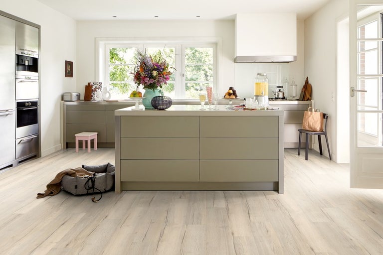 Cameră luminoasă cu bucătărie, insulă de bucătărie, mobilă de bucătărie și pardoseală cu aspect de lemn