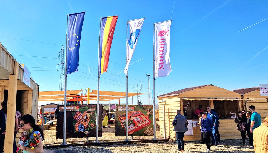 Locație de eveniment cu steaguri, bannere publicitare și vizitatori