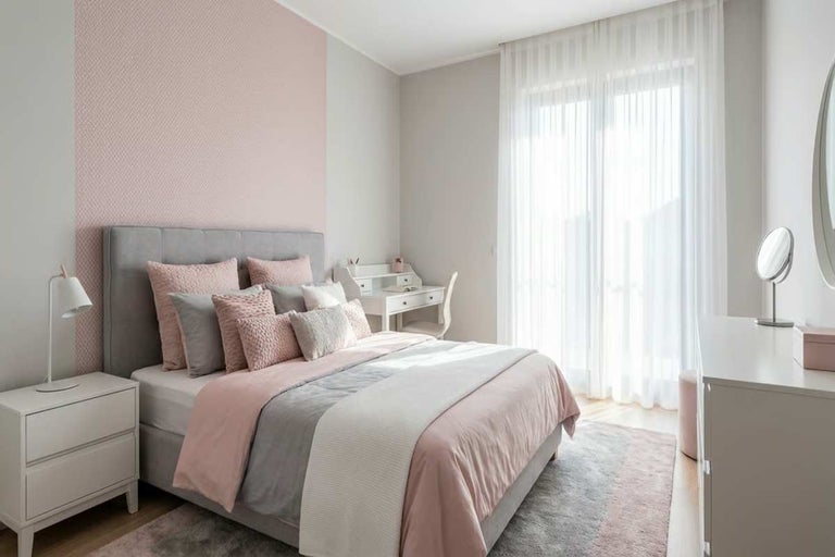 Dormitor luminos cu pat, noptieră, birou și perdele