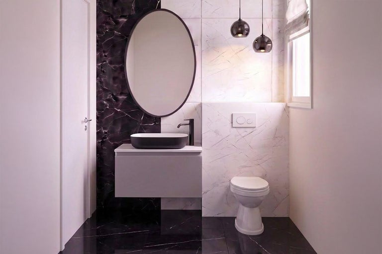 Baie modernă cu mască de chiuvetă gri, oglindă ovală, vas de WC pe pardoseală și plăci ceramice cu aspect de marmură.