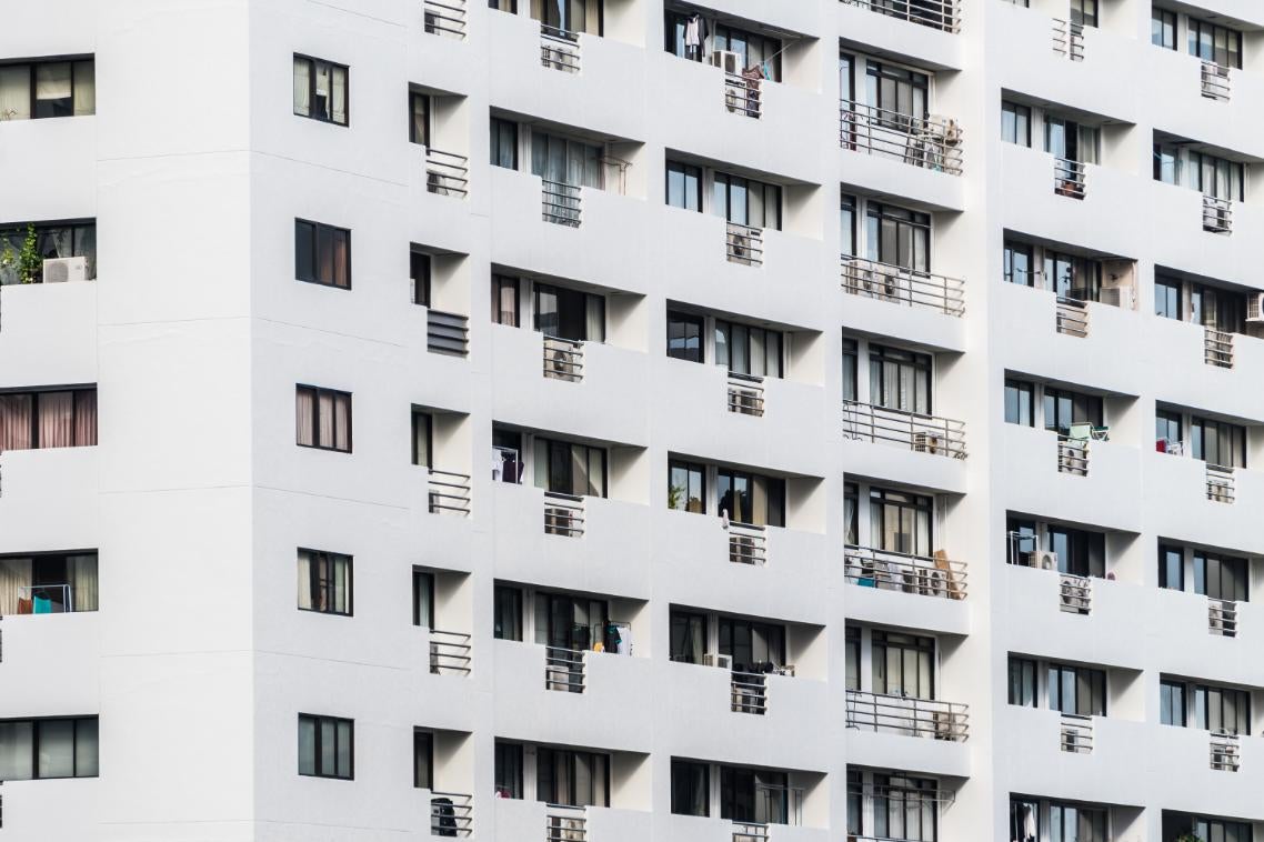 Fațada unui bloc de apartamente cu balcoane și ferestre