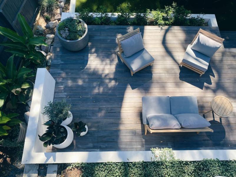 Terasa cu podea de lemn, mobilier de grădină și plante în ghivece