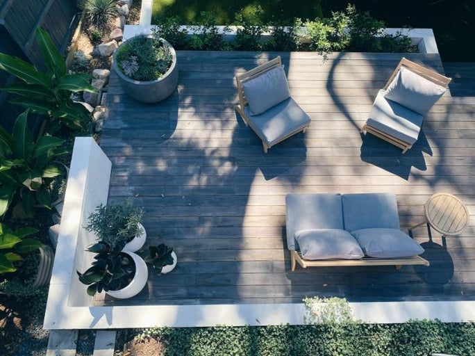 Terasa cu podea de lemn, mobilier de grădină și plante în ghivece