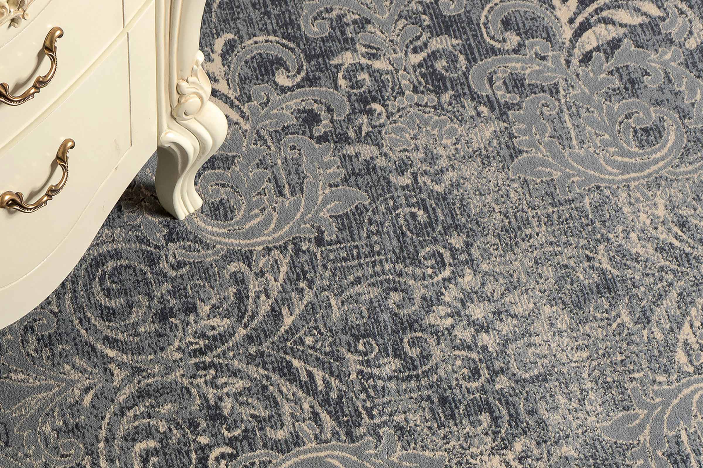 Covor decorativ cu model ornamental lângă un dulap alb