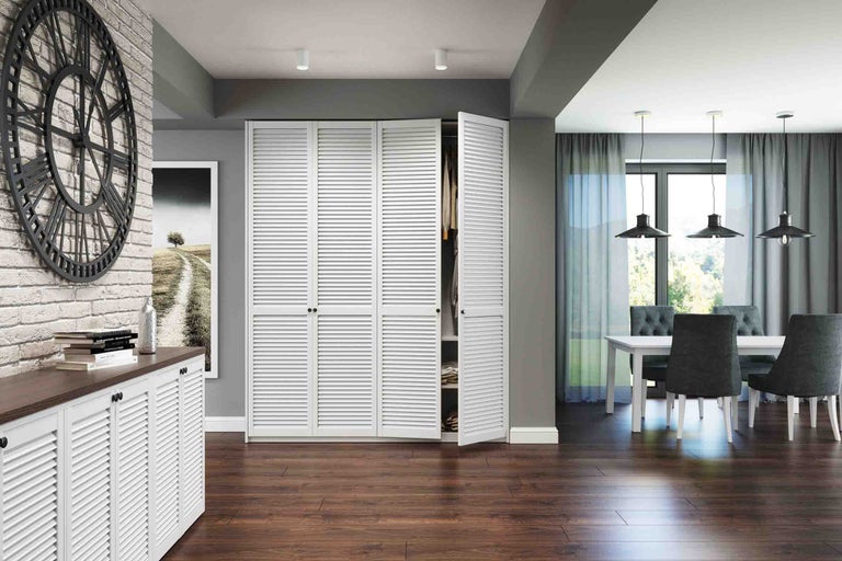 Cameră de zi modernă cu uși cu lamele albe pentru dulapuri încorporate și o comodă, podea din lemn închis, ceas de perete mare și zonă de luat masa.