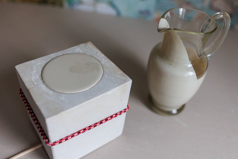 Un cub cu formă și un recipient din sticlă pentru lichide