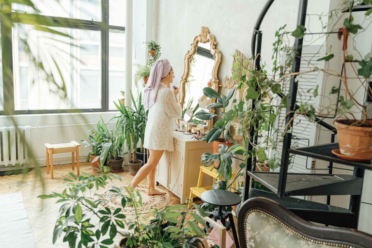 Colțul hygge cu plante - calm, textile, lumânari, frunze mari