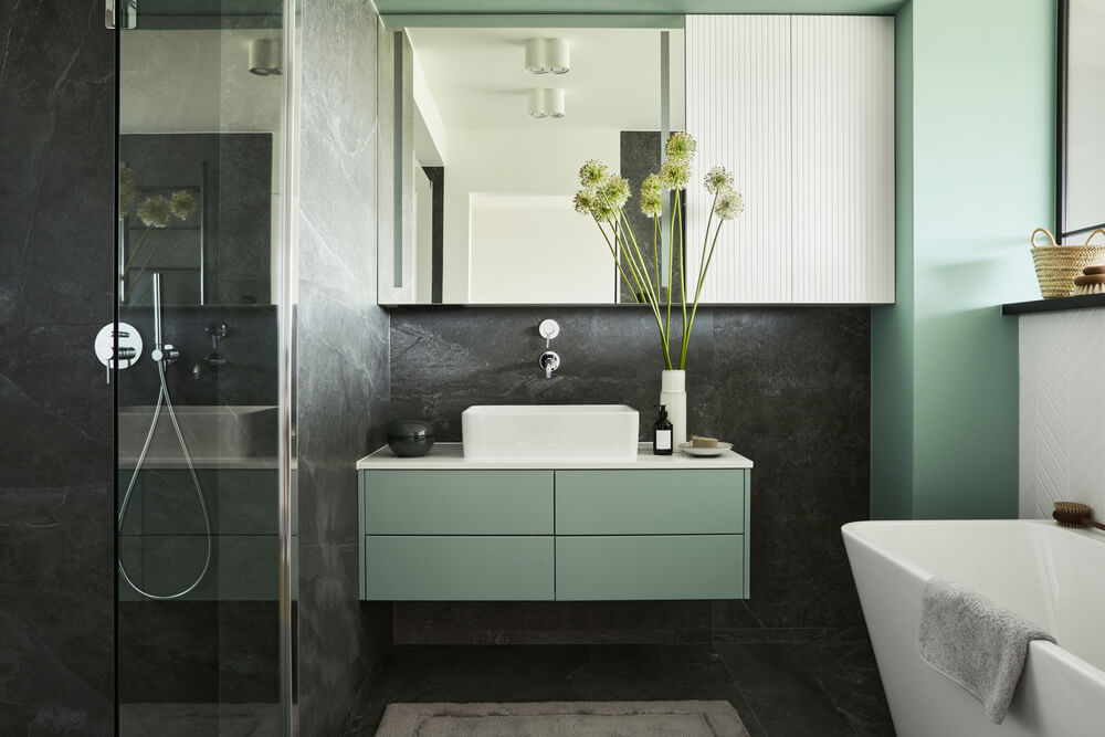 Baie luminoasă cu duș, lavoar și cadă în design modern