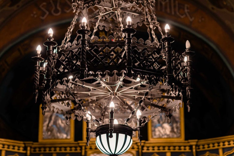 Prim-plan al unui candelabru cu mai multe brațe și cadru metalic filigranat