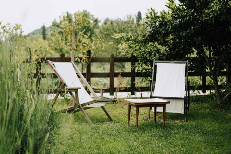 Set de mobilier de grădină cu două șezlonguri și o masă pe un gazon